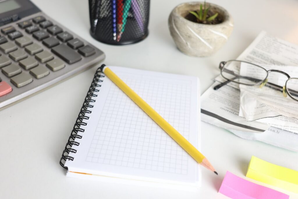 Calculator and stack of invoices on a small business office desk