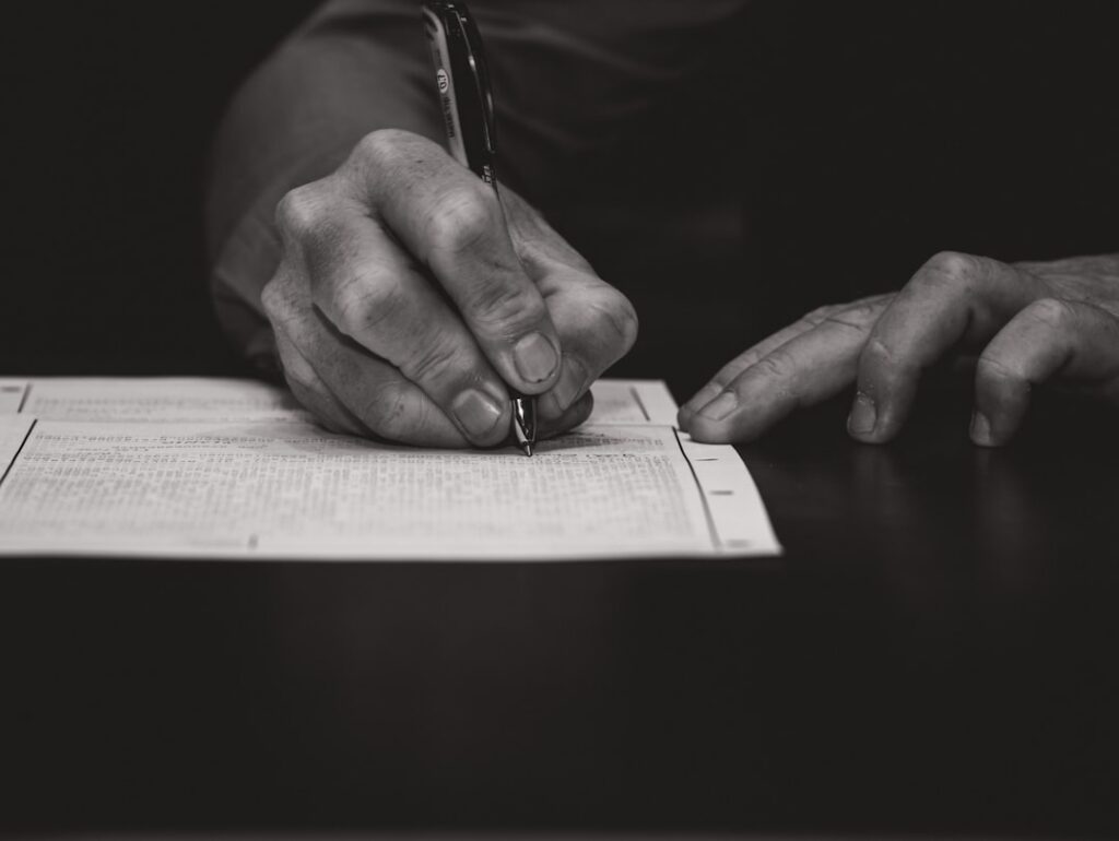 Close-up of a hand signing a personal guarantee page in a business financing contract