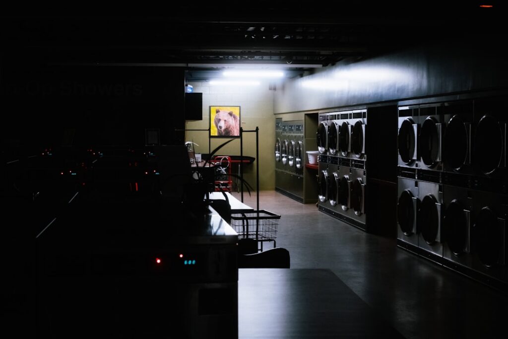Rows of coin-operated washing machines inside a laundromat