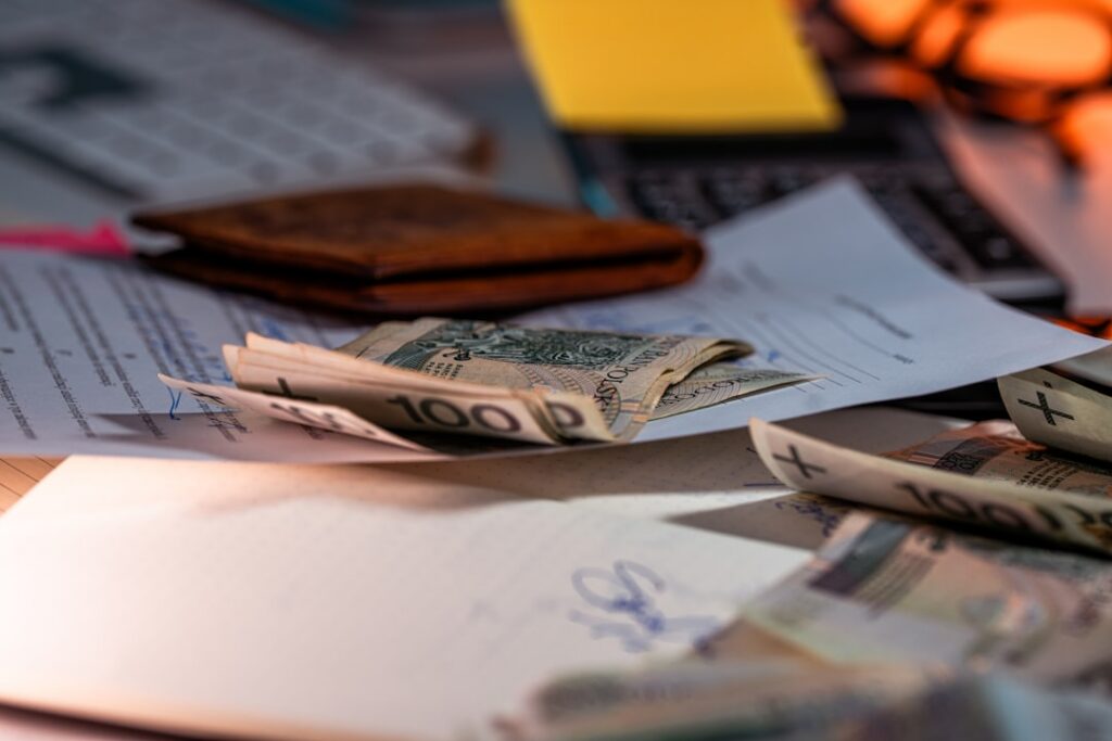 Payroll checks and unpaid invoices spread across a desk