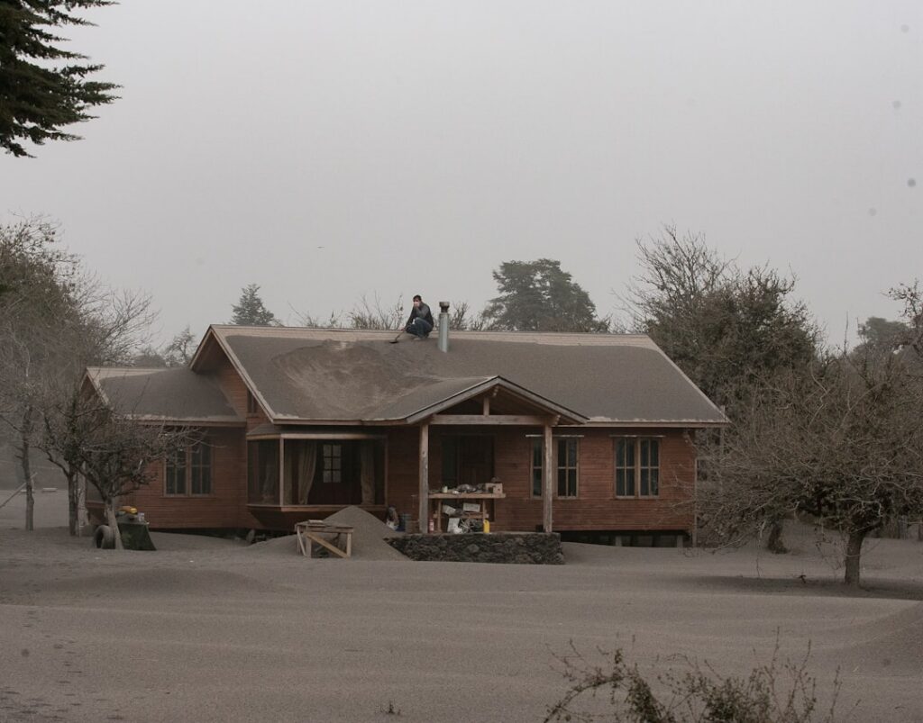 Tree service crew removing a storm-damaged tree from a rooftop