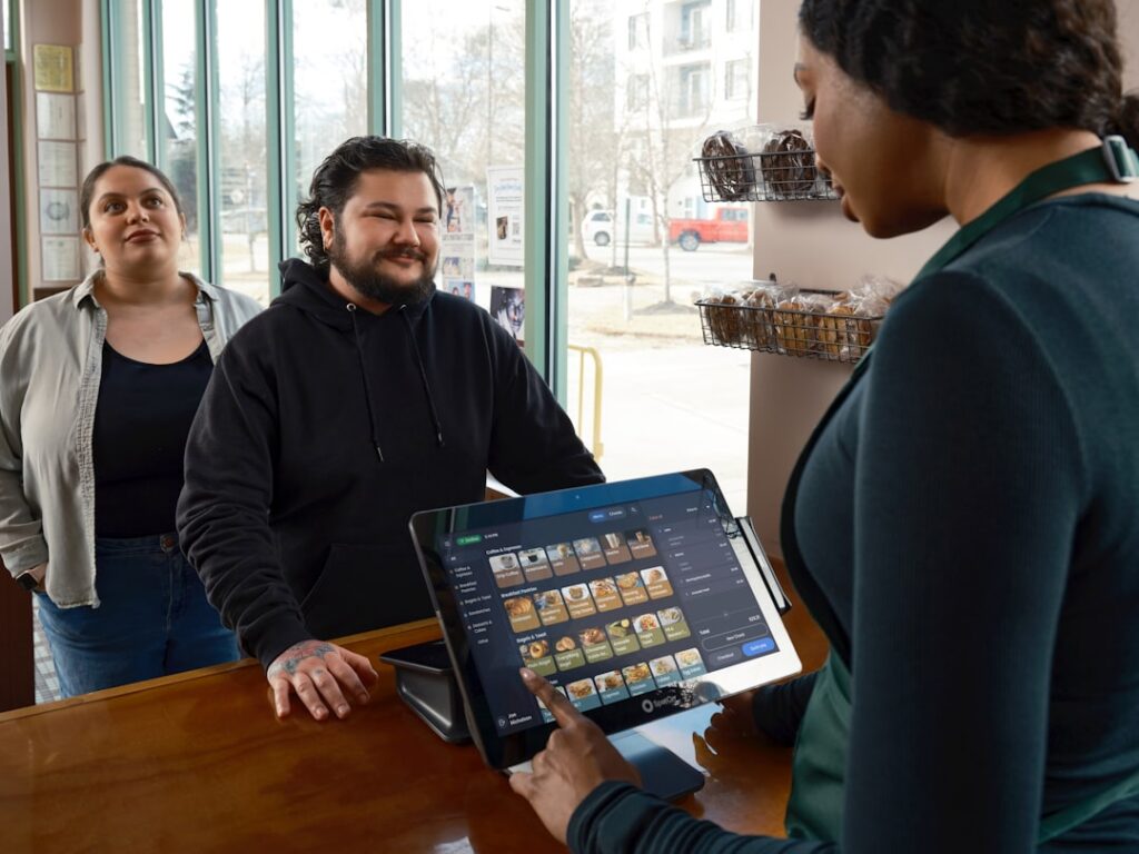 Small business owner anxiously checking a card reader at the register
