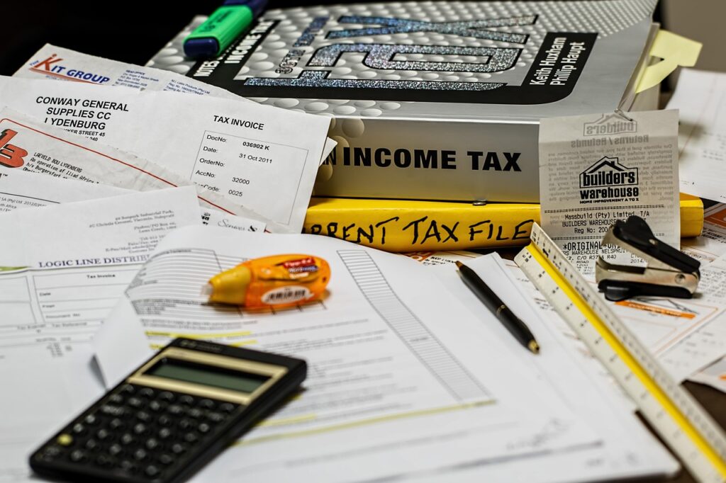 Calculator and invoices next to holiday inventory boxes representing seasonal cash flow swings