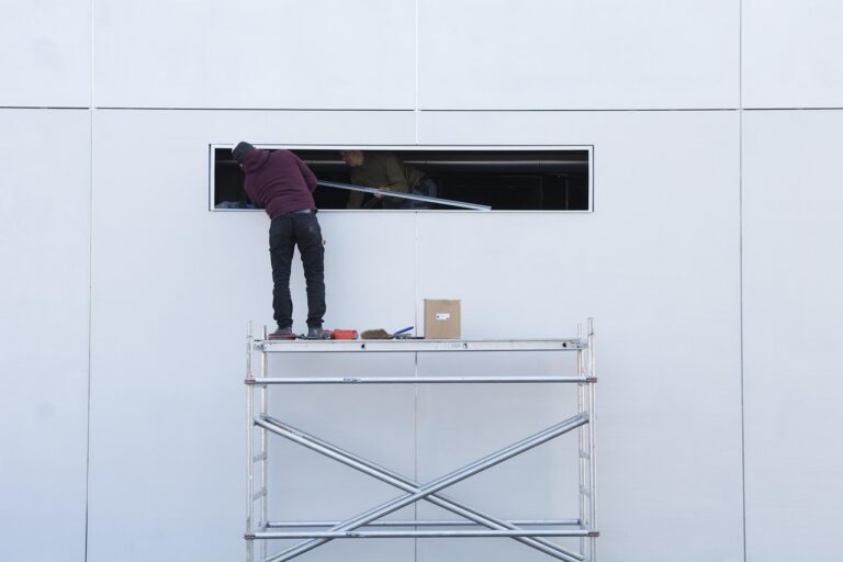 Electrical contractor reviewing paperwork and invoices beside a work van