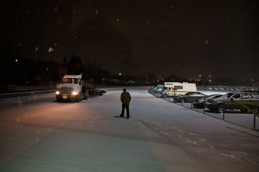 Business owner looking out over a snow-ready truck lot with confidence