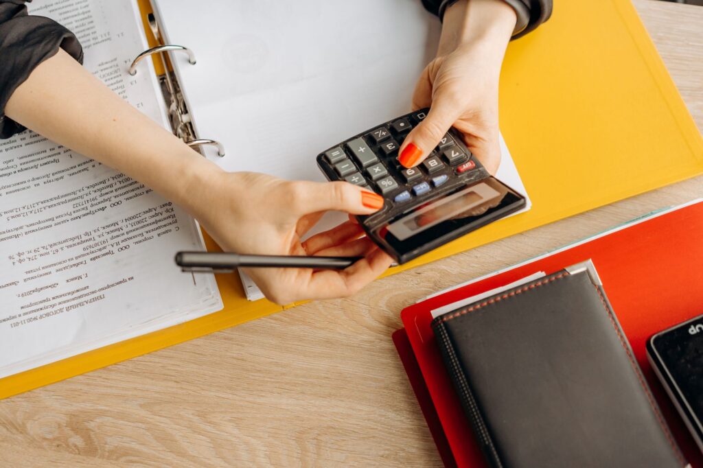 Electrical contractor reviewing invoices and a calculator on site