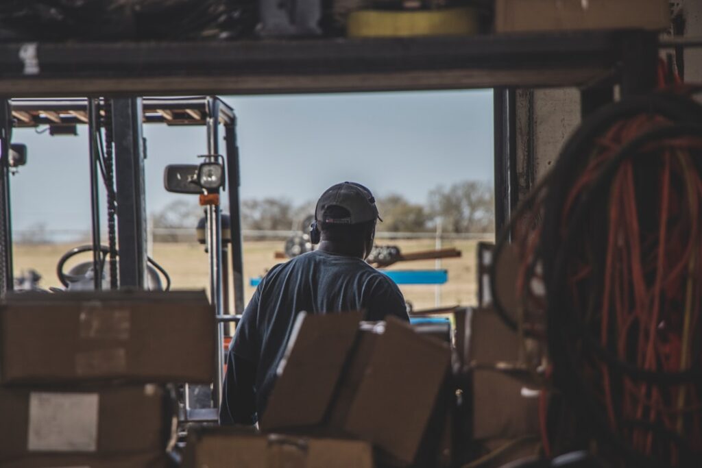 Wholesale distribution business owner reviewing invoices and cash flow paperwork in a warehouse