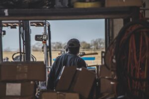 Wholesale distribution business owner reviewing invoices and cash flow paperwork in a warehouse