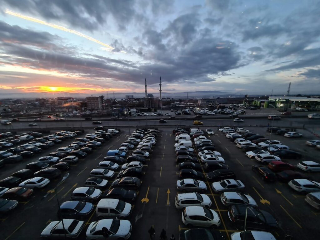 Car dealership inventory lot with vehicles lined up at dusk