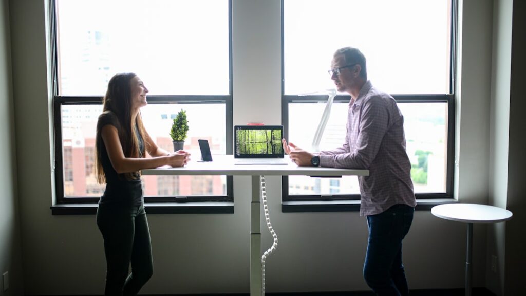 Two people negotiating terms across a small office desk