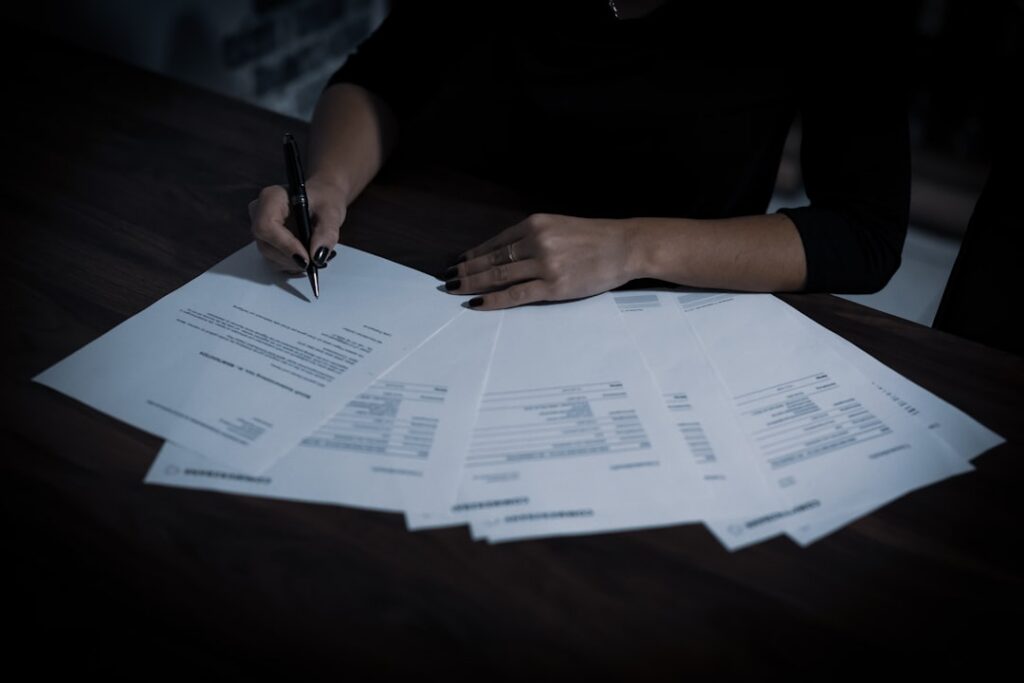 Business owner reviewing several bank statements spread across a desk
