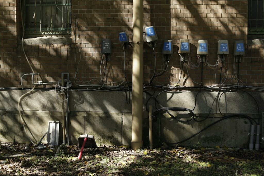 Electrician kneeling to work on an open electrical breaker panel