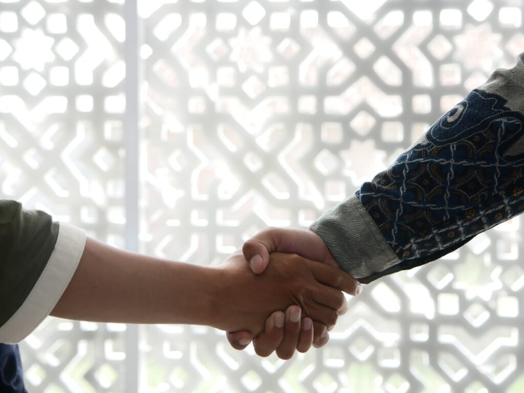 Two people shaking hands after a business debt negotiation meeting