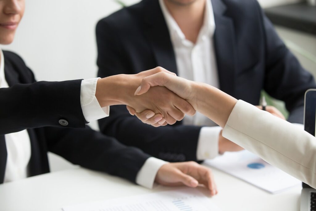 Business owner and advisor shaking hands after reaching a negotiated settlement