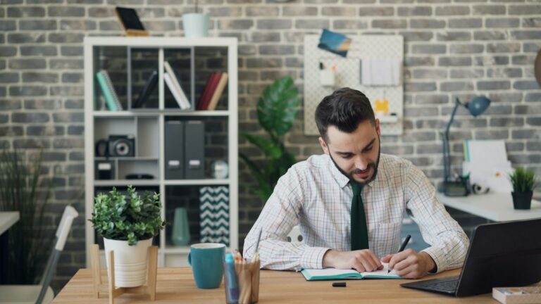 Small business owner reviewing tax paperwork and calculator at a desk