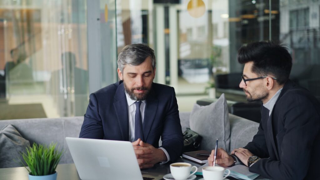 Business owner negotiating repayment terms across a desk with documents and a laptop