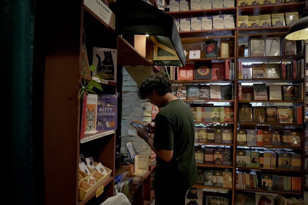 Small gift shop owner checking paperwork beside boxes of holiday inventory