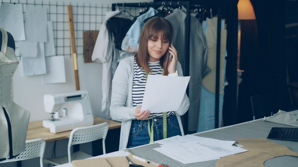 Business owner on a phone call while reviewing contract paperwork