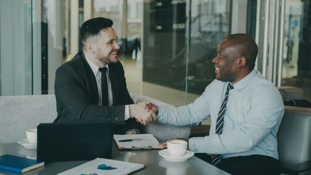 Business owner shaking hands with an advisor across a desk