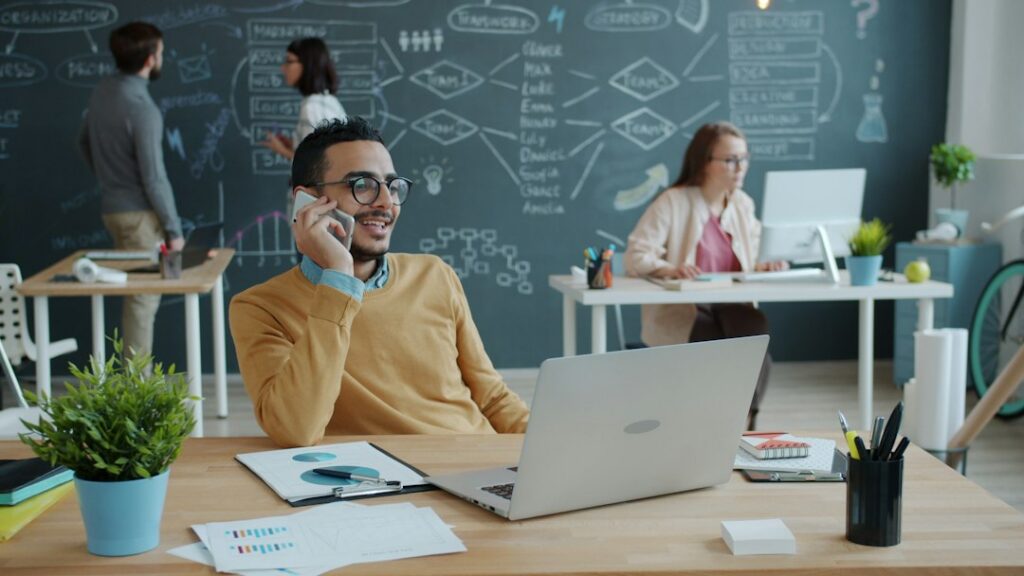Confident small business owner on the phone in a bright office