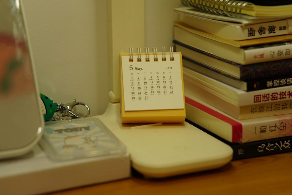 Calendar and clock on a desk beside financial documents, symbolizing a deadline