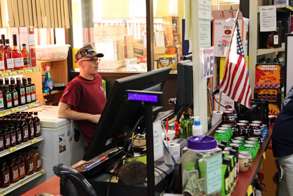 Relieved small business owner at a gift shop counter surrounded by inventory