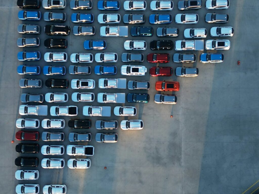 Rows of used cars with price stickers on a dealership lot