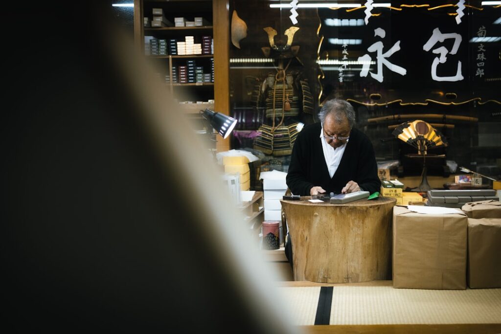 Small gift shop owner checking paperwork beside boxes of holiday inventory