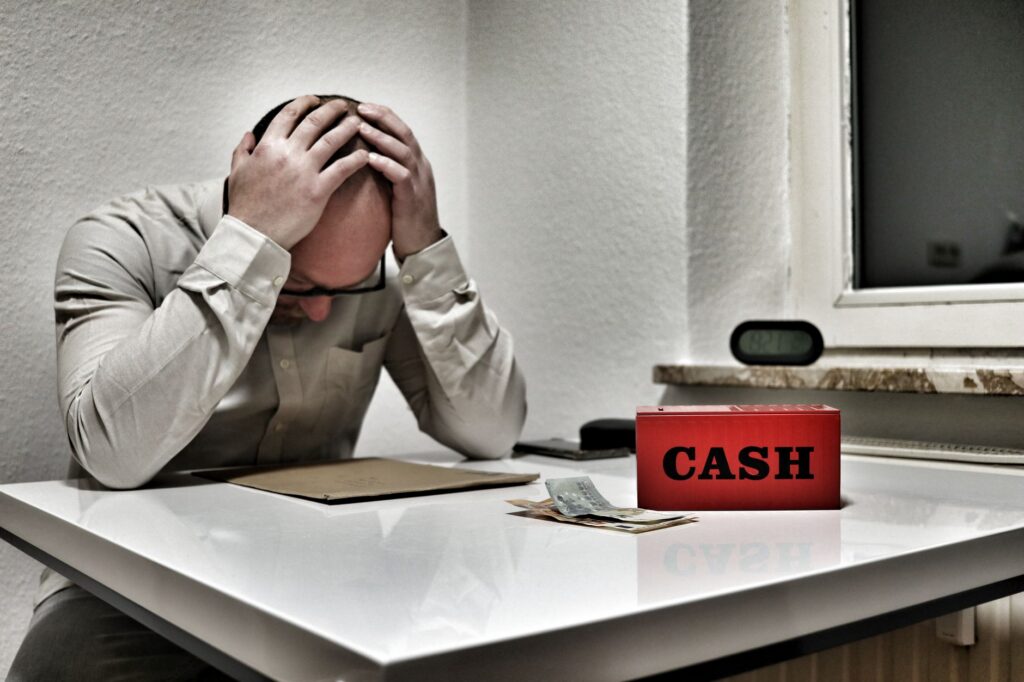 Business owner checking a banking app on a phone with a concerned expression