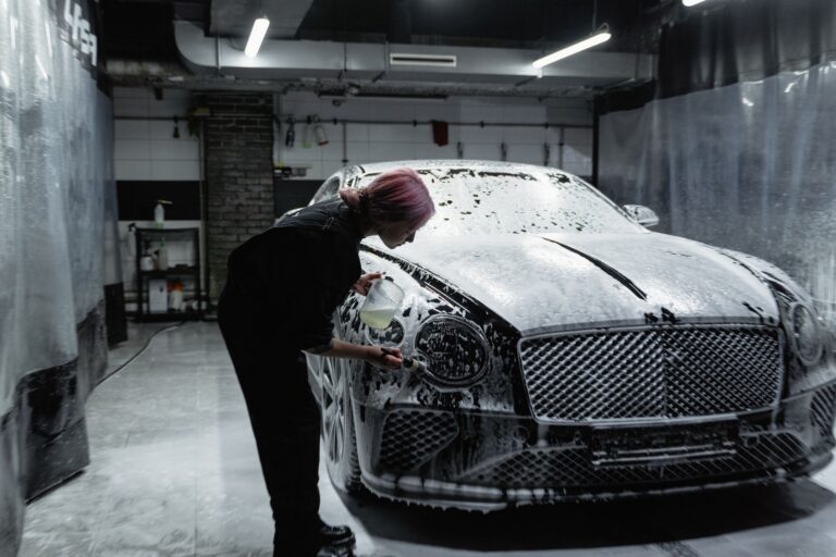 Car wash tunnel with foam and brushes washing a car