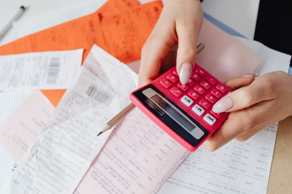 Calculator and stack of supplier invoices on a retail counter