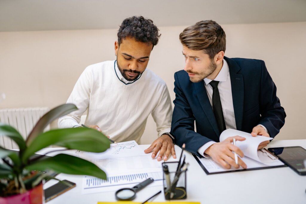 Two people reviewing documents across a small desk