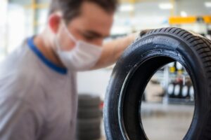 Technician with a stack of winter tires in a tire shop