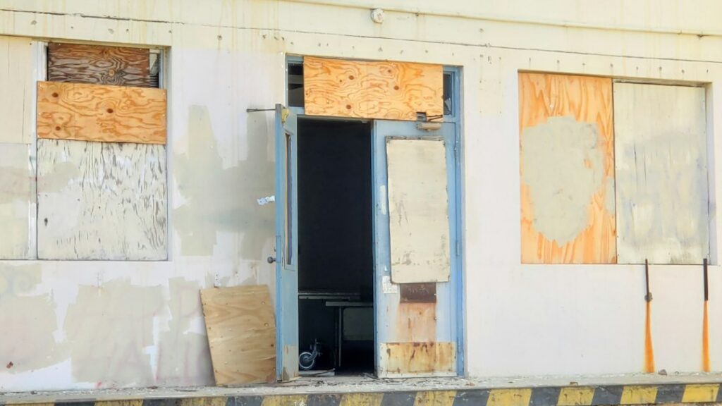 Insurance adjuster inspecting a damaged commercial property with a clipboard