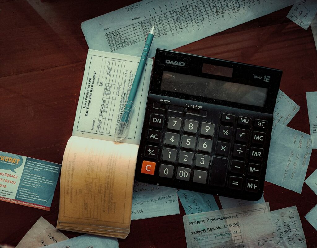 Shop owner reviewing invoices and bills with a calculator