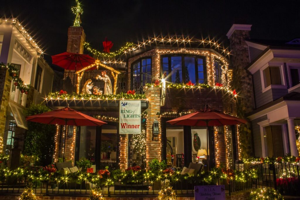Installer hanging holiday lights on a home roofline