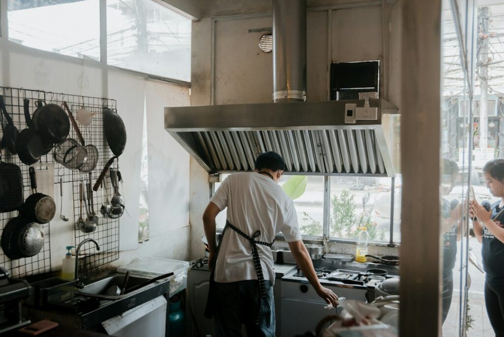 Technician repairing a refrigerator in a home kitchen