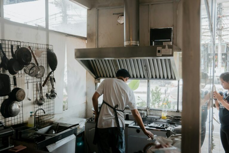 Technician repairing a refrigerator in a home kitchen