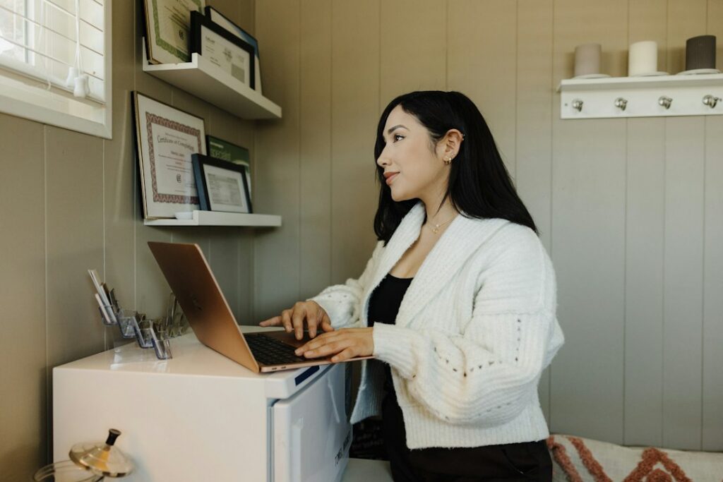 Small business owner checking a bank account balance on a laptop