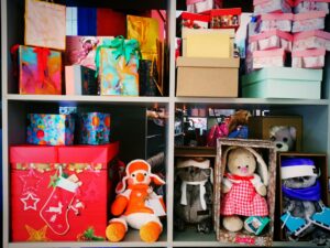 Shop owner stocking shelves with boxes before a holiday sale