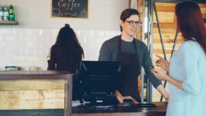Small business owner counting customer deposits