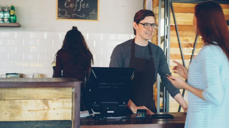 Small business owner counting customer deposits